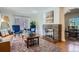 Elegant living room showcasing a brick fireplace, hardwood floors, a decorative rug, and refined decor at 1235 Dahlia St, Denver, CO 80220