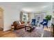 Inviting living room features hardwood floors, a comfortable leather sofa, blue accent chairs, and a stylish rug at 1235 Dahlia St, Denver, CO 80220