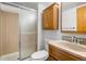 Bathroom featuring a shower with sliding doors, toilet, and wood vanity with cabinets and drawers at 12977 W Dorado Pl, Littleton, CO 80127