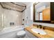 Modern bathroom with a granite countertop, bathtub with tiled walls, and ample storage space at 12977 W Dorado Pl, Littleton, CO 80127