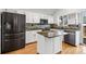 Modern kitchen with stainless steel appliances, island, and white cabinetry at 12977 W Dorado Pl, Littleton, CO 80127