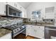 Close up of the kitchen with granite countertops, stainless steel appliances and a tile backsplash at 12977 W Dorado Pl, Littleton, CO 80127