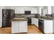 Bright kitchen with white cabinets, a center island, stainless steel appliances, and hardwood floors at 12977 W Dorado Pl, Littleton, CO 80127
