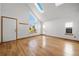 Bright and airy living room featuring hardwood floors, skylights, and a large window at 12977 W Dorado Pl, Littleton, CO 80127