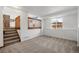 Cozy carpeted living area with stairs leading to the kitchen and backyard-view window at 12977 W Dorado Pl, Littleton, CO 80127