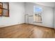 Bright and airy living room with hardwood floors, a large window, and fresh white walls at 12977 W Dorado Pl, Littleton, CO 80127