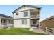 Two-story home with a balcony overlooking a manicured backyard with green artificial turf at 1994 Spencer Ave, Castle Rock, CO 80104
