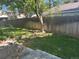 Grassy backyard with a tall tree and brick border on the edge of the lawn and fence at 5612 S Lansing Ct, Englewood, CO 80111