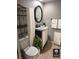 Cozy bathroom with an oval mirror, a plant on the vanity, and white towels on a towel rack at 5612 S Lansing Ct, Englewood, CO 80111