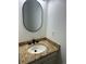 Bathroom featuring a decorative granite countertop and oval mirror at 5612 S Lansing Ct, Englewood, CO 80111