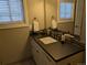 Well-lit bathroom with a dark countertop, white cabinets, and a large mirror providing a clean aesthetic at 5612 S Lansing Ct, Englewood, CO 80111