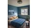 Inviting bedroom with blue walls, a comfortable bed, a sunny window, and a calming atmosphere at 5612 S Lansing Ct, Englewood, CO 80111