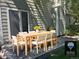 Outdoor patio features an outdoor dining set with a wooden table and white cushioned chairs at 5612 S Lansing Ct, Englewood, CO 80111