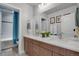 Well-lit bathroom with double sinks, granite countertops, and a shower with a blue curtain at 1921 Hooker St, Denver, CO 80204