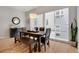 Light-filled dining room with a rustic wood table, bench seating, and large windows overlooking the exterior at 1921 Hooker St, Denver, CO 80204