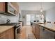 Close-up of the kitchen showing granite countertops, stainless steel appliances, wood cabinets, and hardwood floors at 1921 Hooker St, Denver, CO 80204