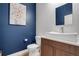 Stylish powder room featuring a vessel sink, modern vanity, textured wall, and blue accent wall at 1921 Hooker St, Denver, CO 80204