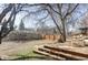 Backyard with a new deck, some outdoor seating, and ample shade from the mature trees in the yard at 2030 Cody St, Lakewood, CO 80215