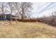 Backyard with lush lawn, garden area, wood fence, and a home with neutral siding and trim at 2030 Cody St, Lakewood, CO 80215