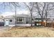 Charming home exterior with inviting front yard, mature trees and covered outdoor seating area at 2030 Cody St, Lakewood, CO 80215