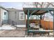 Cozy outdoor seating area with pergola, bench, and table with gray couch cushions at 2030 Cody St, Lakewood, CO 80215