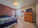 Cozy bedroom featuring a wooden dresser, soft lighting, and a comfortable bed for relaxation at 17548 E 103Rd Dr, Commerce City, CO 80022