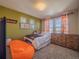 Bedroom with natural light and a large dresser, plus beanbag chair and warm, inviting colors at 17548 E 103Rd Dr, Commerce City, CO 80022