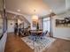 Open-concept dining room with hardwood floors, a decorative rug, and a smooth transition to the stairwell and entry door at 17548 E 103Rd Dr, Commerce City, CO 80022