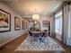 Elegant dining room with wood floors, a cozy rug, and modern decor, adjacent to a staircase and a window at 17548 E 103Rd Dr, Commerce City, CO 80022