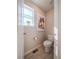 Charming powder room with a stylish toilet, artwork, and a window offering natural light at 17548 E 103Rd Dr, Commerce City, CO 80022