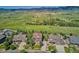 Aerial view of the house in a neighborhood surrounded by trees, green lawns, and mountains in the distance at 7603 Yule Ct, Arvada, CO 80007