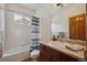 Clean bathroom with tub/shower combination, single sink vanity, and neutral tile at 7603 Yule Ct, Arvada, CO 80007