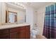 Bright bathroom featuring a vanity with one sink, and shower with decorative curtains at 7603 Yule Ct, Arvada, CO 80007