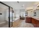 Bright bathroom featuring a glass-enclosed shower, soaking tub, and dual sink vanity at 7603 Yule Ct, Arvada, CO 80007