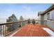 Exterior shot of a deck with wooden floorboards and black metal railings overlooking the yard at 7603 Yule Ct, Arvada, CO 80007