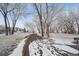 Winter park view with snow-covered ground, bare trees, and a park bench at 7603 Yule Ct, Arvada, CO 80007