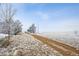 Snowy field on a lot with a walking path with frozen trees at 7603 Yule Ct, Arvada, CO 80007