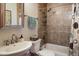 Traditional-style bathroom featuring tiled shower and tub, sink, and toilet at 636 Chute Rd, Golden, CO 80403