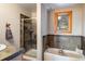 Bathroom showcasing a tub, shower, natural stone accents, and a window with tree views at 636 Chute Rd, Golden, CO 80403