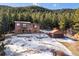 Exterior of log-sided home featuring an attached garage, deck, and wooded surroundings at 636 Chute Rd, Golden, CO 80403