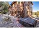 Back exterior of log sided home with hot tub, deck, and outdoor seating at 636 Chute Rd, Golden, CO 80403