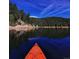 Picturesque lake view from a kayak, reflecting the clear blue sky and tree lined shore at 636 Chute Rd, Golden, CO 80403