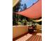 Inviting patio with wooden deck, grill and shade coverings surrounded by mature trees at 636 Chute Rd, Golden, CO 80403