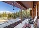 Inviting porch with views of the forest has seating and decorative hanging elements at 636 Chute Rd, Golden, CO 80403