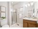 Bright bathroom with glass-enclosed shower, wood vanity, and modern fixtures create a clean and inviting space at 19377 E Radcliff Pl, Aurora, CO 80015