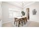 Elegant dining room with a marble table, modern chairs, and ample natural light from the large window at 19377 E Radcliff Pl, Aurora, CO 80015