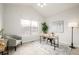 Well-lit office with vaulted ceiling features a large window, modern desk, and cozy seating area at 19377 E Radcliff Pl, Aurora, CO 80015
