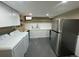 Modern laundry room with white cabinets, stainless steel appliances, and plenty of counter space at 1625 N Downing St, Denver, CO 80218