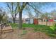 Spacious backyard with lush grass, garden beds, storage buildings, and a colorful privacy fence at 3278 S Lafayette St, Englewood, CO 80113