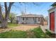 Backyard area with patio and furniture, detached garage, and a well-maintained lawn at 3278 S Lafayette St, Englewood, CO 80113